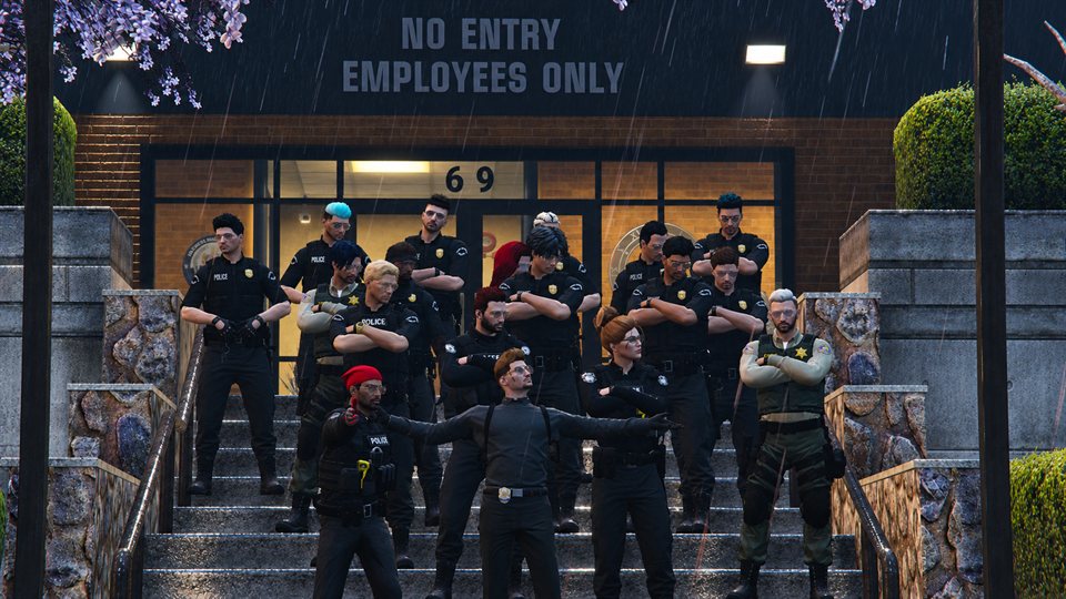 Department members together outside the police station in the rain